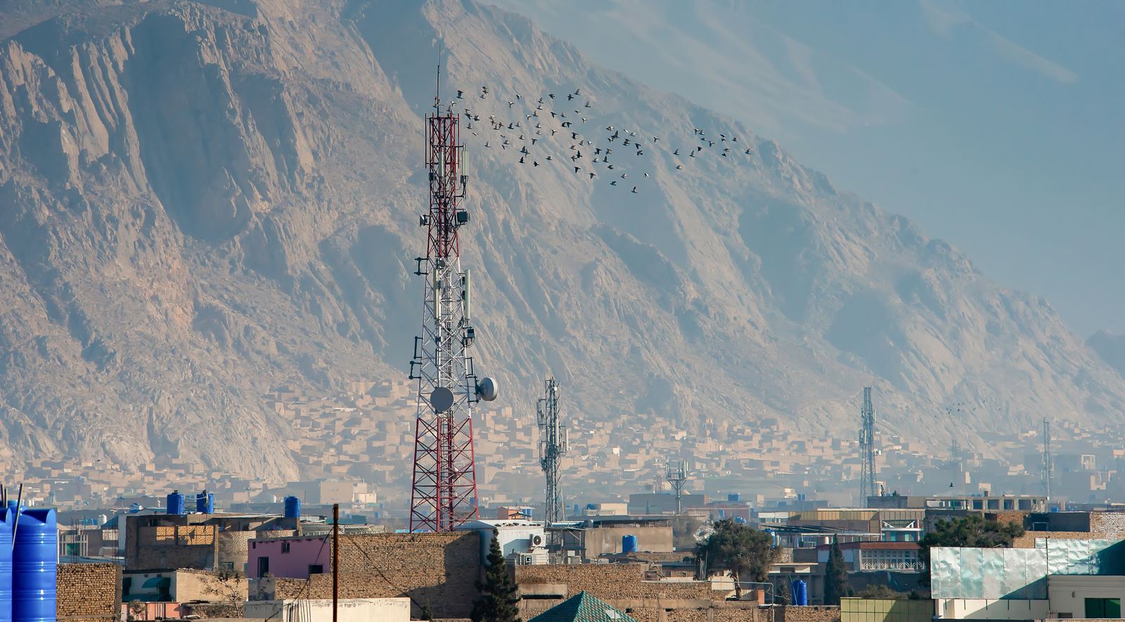 Telecoms tower above the city, with mountains behind